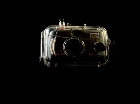 Film camera in a waterproof case, on a black background. Digital camera in a protective case. Photographic equipment for underwater photography.の写真素材