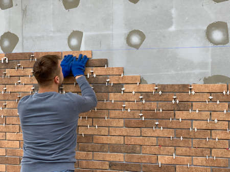 Masters tiled the facade of the house. Builders adorn the walls of a brick mansion. Decorating the...
