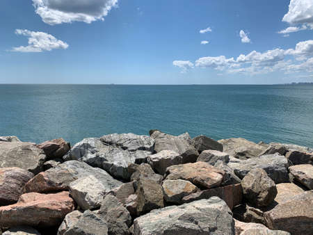 Background texture: large stones of various shapes in the sea. A pile of granite boulders against...