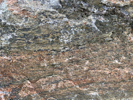 Background texture: the structure of a large stone. Granite boulder close up. Irregularities and...