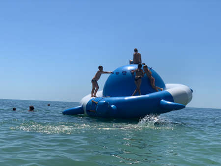 Children swim in the sea on an inflatable attraction. A trampoline on the water for children's...