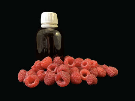 Red raspberries and medicines on a black background. Ripe raspberries for prevention and treatment. Concept: Disease prevention, immunity strengthening.の写真素材