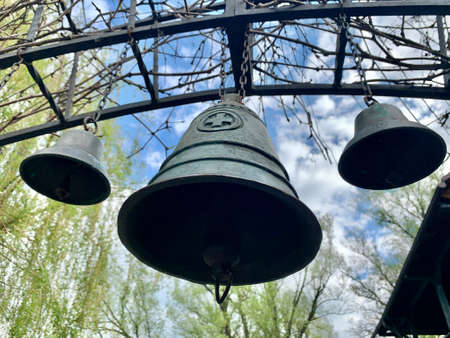 Church bell against the blue sky. Ancient bells in the courtyard of the old castle. Bell tower of an old European church.の写真素材