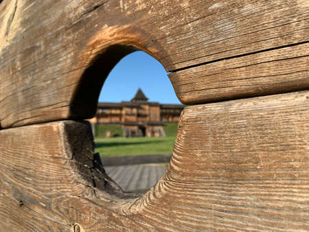 Wooden structure with a circular opening. View of a building and landscape through the opening.の写真素材