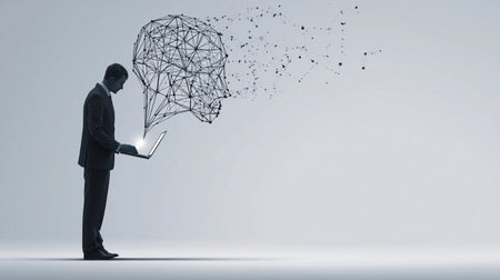 Professional man stands with a laptop as abstract connections form a digital head silhouette in a minimalist environmentの素材