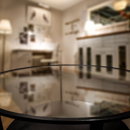 Glass coffee table in the blurred home interior. Home background and copy empty space for your products, text or decoration.の写真素材
