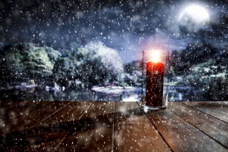Snowy winter glimmering and shiny moonlight night landscape with wooden board top and lit lantern for products and decorations.の写真素材