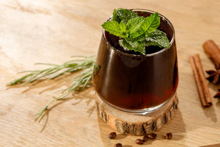 Mulled wine with cinnamon, anise and mint on wooden background