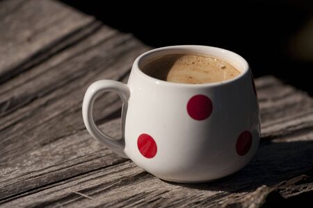 Cappuccino in a cup on a wooden tableの写真素材