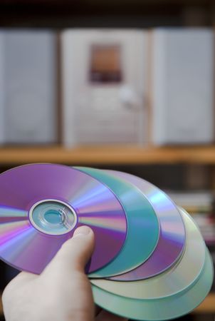 Hand holding CD media in front of hi-fi towerの写真素材