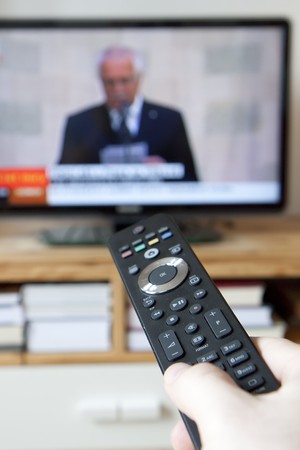 Watching tv and using remote controllerの写真素材