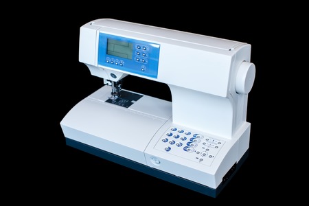 Full automatic sewing machine isolated on the dark background