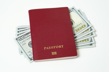 Foreign biometric passport with dollars isolated on a white background. Five bills for a hundred dollars. The concept of tourism. The concept of investment. Closeup.の写真素材