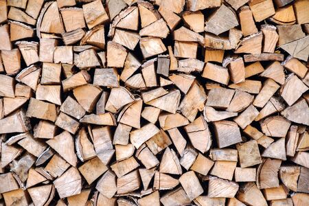 Background of chopped, sawn and stabbed stacked wooden logs.の写真素材