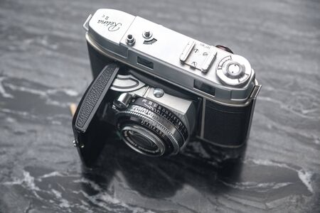 RUSSIA, MOSCOW - September 02, 2019: Vintage analog film camera with a lens and a charged film on a marble stone backgroundのeditorial素材