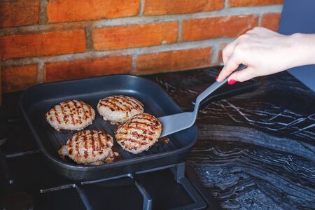 Fresh meat cutlets in a grill pan. Juicy meat steak in a pan. Cooking a burger at home. Delicious and healthy food concept.の写真素材