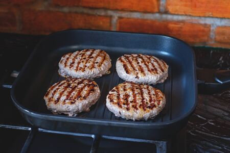 Fresh meat cutlets in a grill pan. Juicy meat steak in a pan. Cooking a burger at home. Delicious...