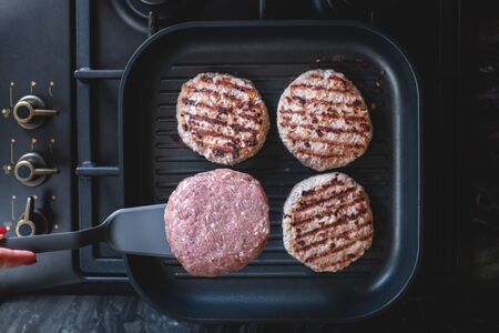 Fresh meat cutlets in a grill pan. Juicy meat steak in a pan. Cooking a burger at home. Delicious and healthy food concept.の写真素材
