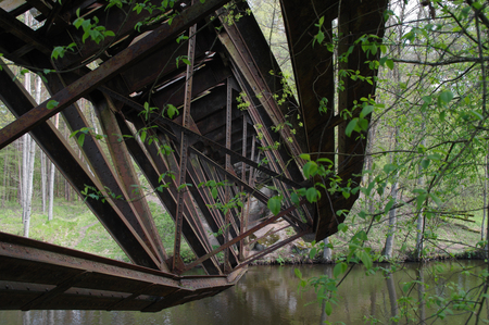 Destroyed railway bridge over the river, in the woodsの写真素材