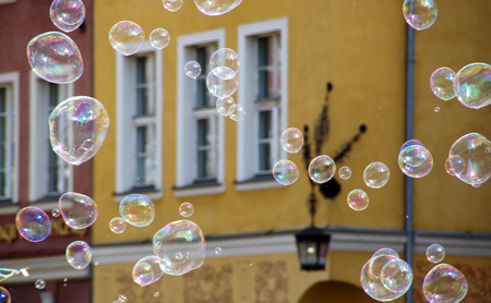 Soap bubbles in city with old buildings in background