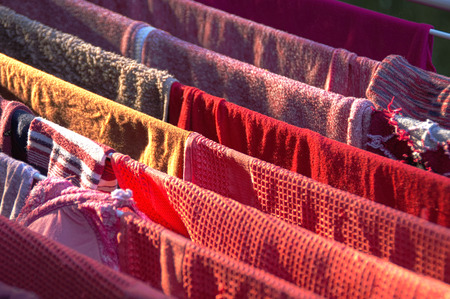 Color clothes drying on wire outside in sunny dayの写真素材