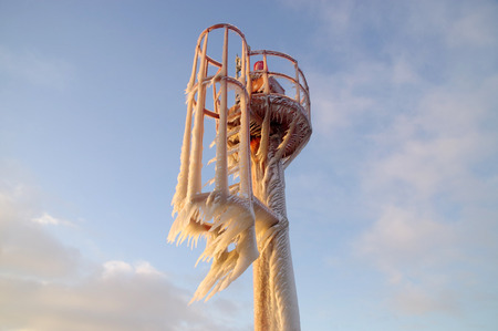 Skyline of icicles on the frozen harbor lamp. Winter by the sea.の写真素材