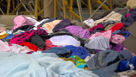 Abandoned heap of old worn clothes. Scattered colorful fabric.の写真素材