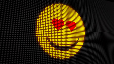 Emoticon love face on big LED display with large pixels. Bright light love expression icon on bulbs display stylized 3D illustration.の写真素材