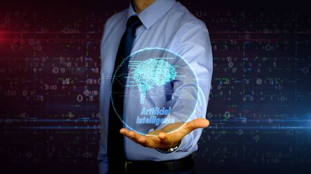 Man with dynamic cybernetic brain symbol hologram on hand. Businessman and futuristic concept of artificial intelligence, deep learning and cyber mind with light and glitch effect.の写真素材