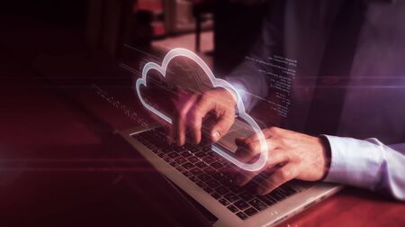 Man typing on laptop with data cloud hologram screen over keyboard. Data computing, online storage...