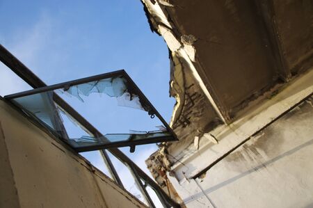 Broken window in the window frame. Old forgotten building. Contemporary Ruins.