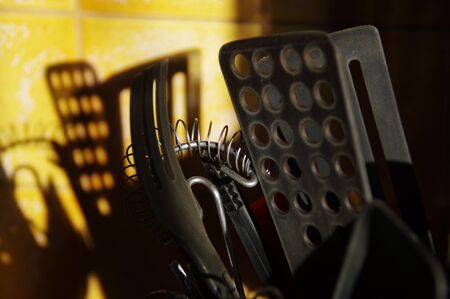 Kitchen tools that cast a shadow on the ceramic wall. Morning in the kitchen.の写真素材
