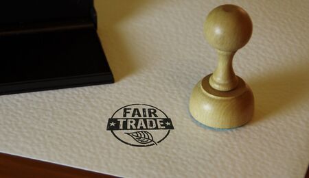 Fair Trade stamp and stamping hand. Ethical business, green trade, sustainable economy and environmental care  concept.の写真素材