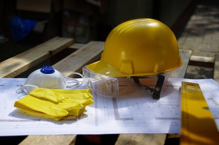 Helmet, goggles, mask and gloves. Personal protective equipment on construction site. Heavy industry...