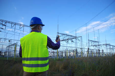Engineer in a helmet with a meter. Electric power production and energy industry.の写真素材