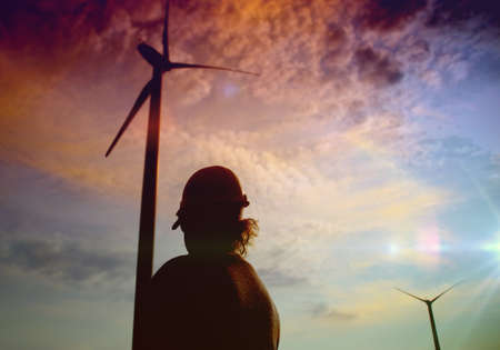 Engineer in a wind turbine. A woman in a helmet supervises the operation of the electric windmills....