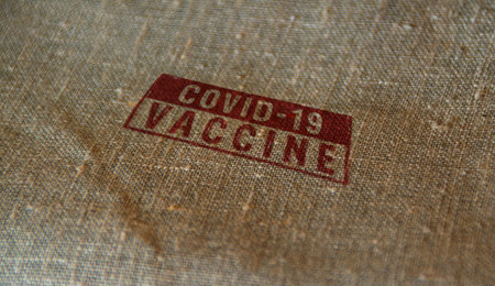Vaccinated covid-19 stamp printed on cardboard box. Virus epidemic, vaccine against COVID-19, medicine, health and disease resistance concept.の写真素材