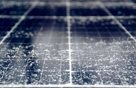 Snowflakes on solar panels. Electricity production from the sun and photovoltaic in winter season.の写真素材