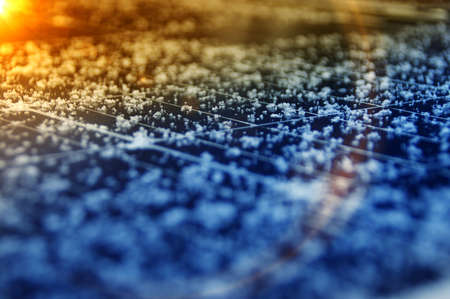 Snowflakes on solar panels. Electricity production from the sun and photovoltaic in winter season.
