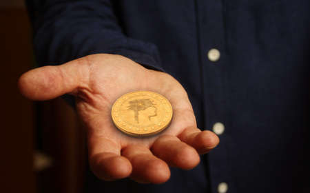 Artificial intelligence AI symbol golden coin in hand abstract concept.の写真素材