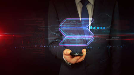 Solana sign concept, SOL cryptocurrency token, blockchain currency, fintech and business technology. Businessman touch the hologram display in hand. Futuristic technology abstract.の写真素材