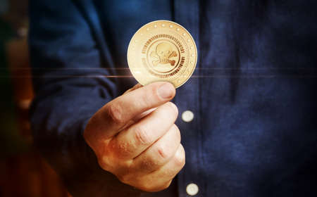 Piracy skull haking symbol, cyber attack and crime golden coin in hand abstract concept.の写真素材