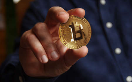 Bitcoin BTC cryptocurrency golden coin in hand abstract concept