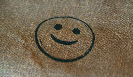 Smiley emoticon icon symbol stamp printed on linen sack. Smile emoji concept.