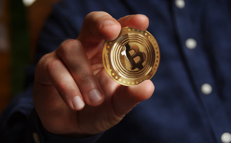 Bitcoin ETF BTC cryptocurrency golden coin in hand abstract conceptの写真素材
