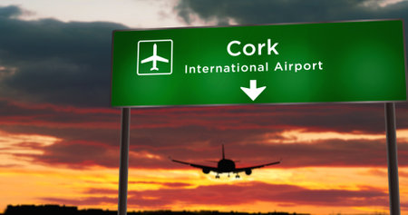 Airplane silhouette landing in Cork, Ireland. City arrival with airport direction signboard and sunset in background. Trip and transportation concept 3d illustration.の写真素材