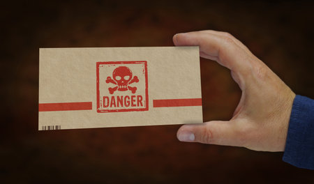 Danger with skull symbol box in hand. Toxic gambling sign cardboard pack factory. Abstract concept 3d illustration.の写真素材