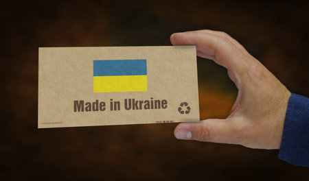 Made in Ukraine box in hand. Ukrainian, flag manufacturing and delivery. Product factory, import and export. Abstract concept 3d illustration.の写真素材