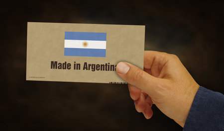 Made in Argentina box in hand. Argentinian flag manufacturing and delivery. Product factory, import and export. Abstract concept 3d illustration.の写真素材