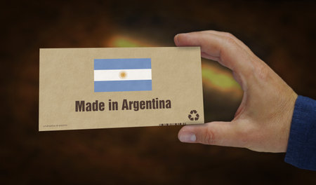 Made in Argentina box in hand. Argentinian flag manufacturing and delivery. Product factory, import and export. Abstract concept 3d illustration.の写真素材
